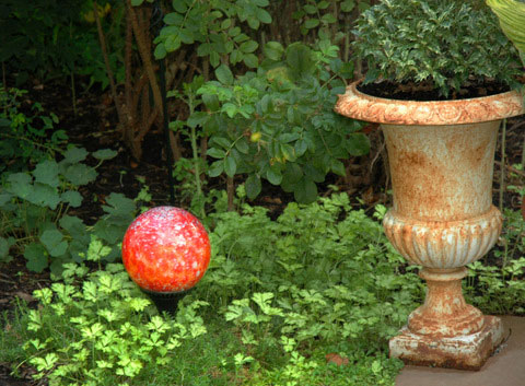 Eight inch nightorb light sphere next to classic urn