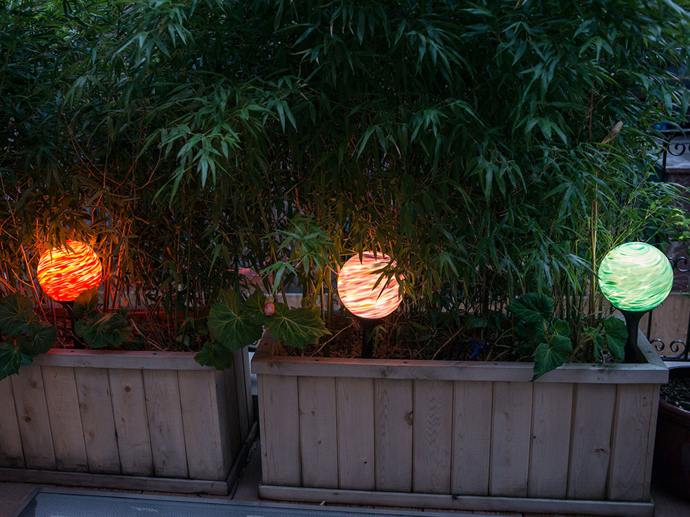 Three nightorbs spicing up potted plants with low voltage lighting