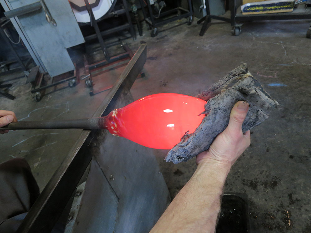 Gaffer shaping hot glass before insertion into an 8 inch mold